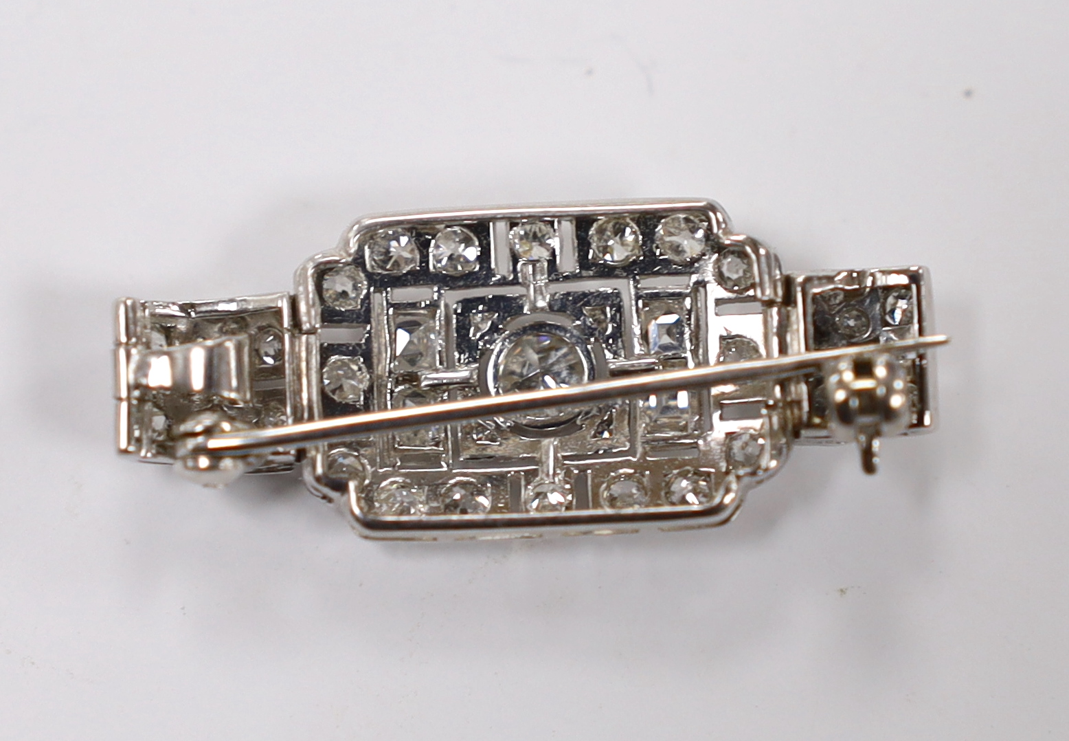 An Art Deco style white metal and millegrain set round and square cut diamond cluster pendant brooch, 33mm, gross weight 6.1 grams.